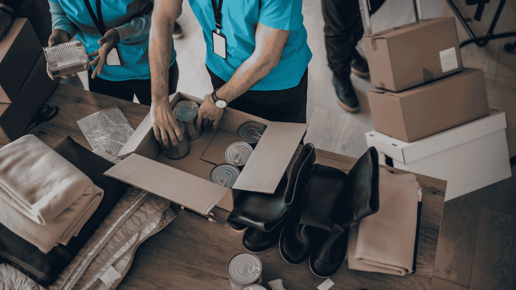 Team members organizing items into boxes, showcasing the detailed and efficient packing services offered by Clockwork Moving Company in Charlotte, NC. Team members organizing items into boxes, showcasing the detailed and efficient packing services offered by Clockwork Moving Company in Charlotte, NC.